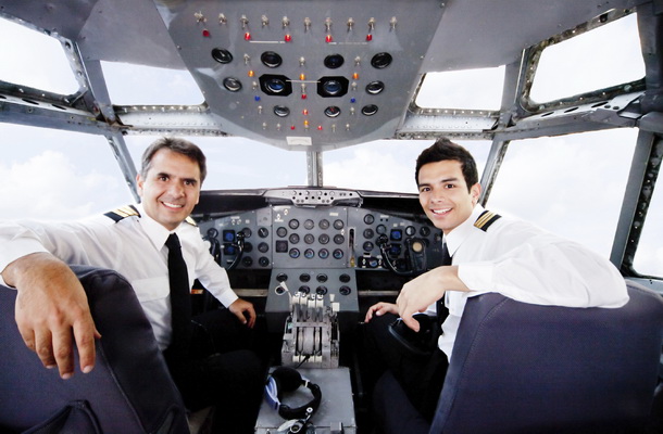 Pilots sitting in an airplane cabin flying and smiling