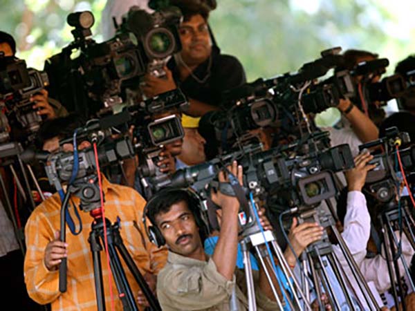 Television cameramen take pictures of India's Prime Minister Manmohan Singh, who is on his way to submit his resignation to President Pratibha Patil at the presidential palace in New Delhi May 18, 2009. The Congress-led coalition eyed possible new allies on Monday after a decisive general election victory raised hopes of a stable government and sent financial markets soaring. REUTERS/Arko Datta (INDIA POLITICS) - RTXIPKS