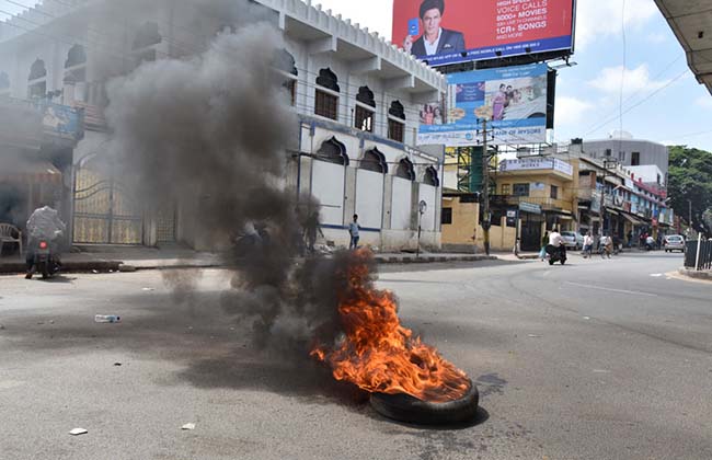 Kannada activist protest by burning a tyre at Hebbal during a State-wide bandh against the Supreme Court order to release Cauvery water to Tamil Nadu in Bengaluru on Friday. Photo by BK Janardhan