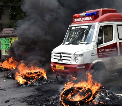 An Ambulance moves in between the fire put by the Kannada activists during the Karnataka Bundh called by the various Kannada organisations against the Supreme Court order on Cavery water issue, at New Guddadahalli in Bengaluru on Friday. -Photo/ M S MANJUNATH